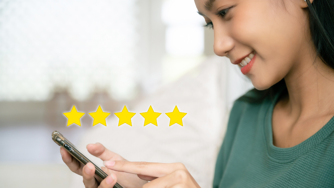 smiling women giving five star rating using her phone